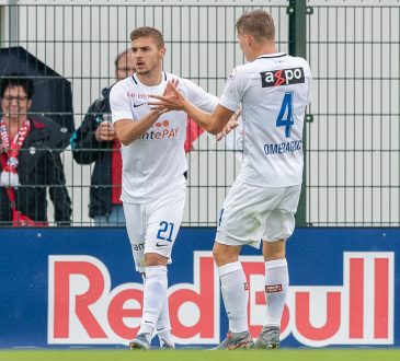 Ein Hertha Spieler lässt sich mit einer Hand ins Gesicht. Der Hintergrund erscheint nur Schwarz