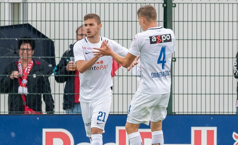 Ein Hertha Spieler lässt sich mit einer Hand ins Gesicht. Der Hintergrund erscheint nur Schwarz