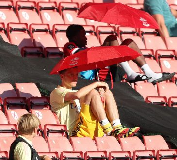 Mesut Özil versteckt sich unter einem Sonnenschirm auf der Tribüne im Spiel gegen Southampton