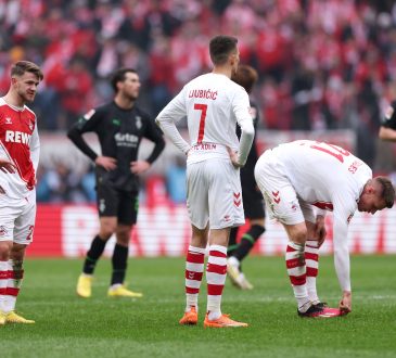 Vier Spieler des FC. Köln und zwei Spieler der Borussia Mönchengladbach stehen während dem Rheinderby auf dem Platz.