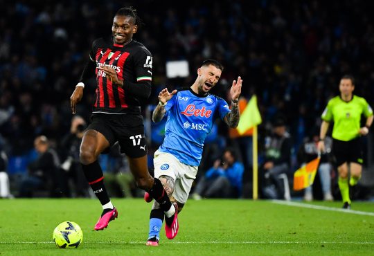 Rafa Leao vom AC Milan läuft mit dem Ball davon, während ein Neapel Spieler hinfällt.