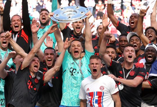 Die Spieler des FC Bayern feiern die Meisterschaft. Manuel Neuer im Zentrum hält die Meisterschale in die Höhe.