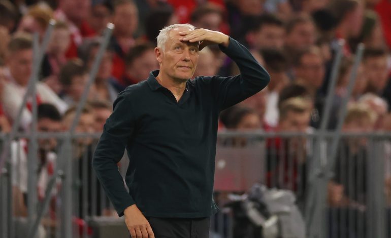 Christian Streich an der Seitenlinie mit einem Arm oben am Kopf.