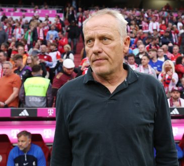 Christian Streich steht mit neutralem Gesichtsausdruck vor der Trainerbank