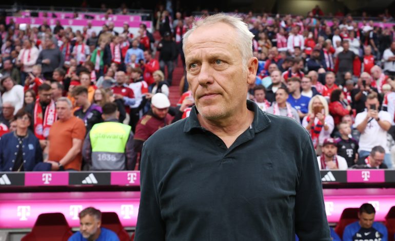 Christian Streich steht mit neutralem Gesichtsausdruck vor der Trainerbank