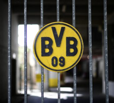 Das Logo von Borussia Dortmund auf einem Zaun. Der Text handelt von Oliver Lukic