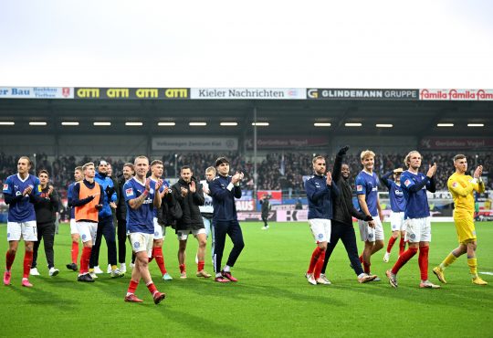 Die Spieler von Holstein Kiel feiern mit den Fans nach dem Sieg gegen den HSV