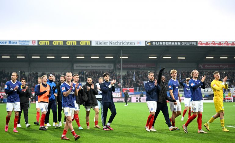 Die Spieler von Holstein Kiel feiern mit den Fans nach dem Sieg gegen den HSV