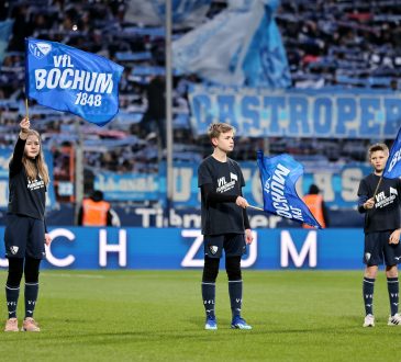 drei Kinder schwenken Bochum Fahnen beim einlaufen der Spieler