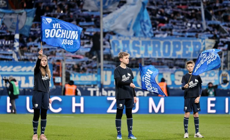 drei Kinder schwenken Bochum Fahnen beim einlaufen der Spieler