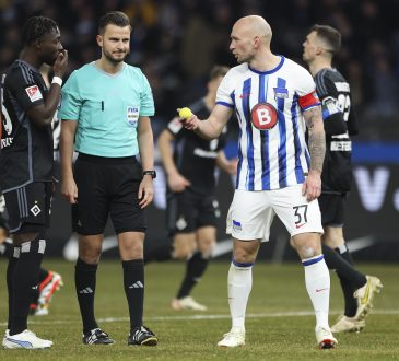 Herthas Toni Leistner mit einem Tennisball in der Hand berät sich mit dem Schiedsrichter und Hamburgs Verteidiger Stephan Ambrosius