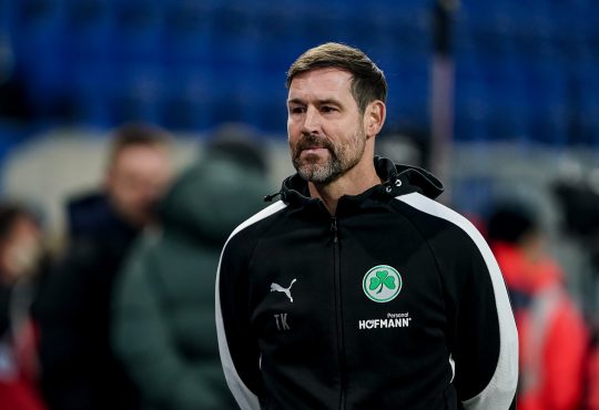 Im Bild sieht man Thomas Kleinen, Ex-Trainer von Greuther Fürth. Seine Arme sind verschränkt an seinen Rücken gezogen.