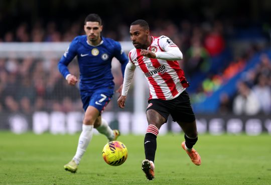 Rico Henry läuft mit dem Ball an einem Spieler von Chelsea vorbei.