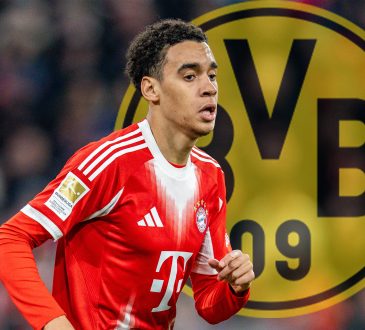 Jamal Musiala im Trikot von Bayern München. Im Hintergrund das Logo von Borussia Dortmund.