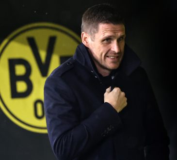 Sebastian Kehl steht vor dem Borussia Dortmund Logo