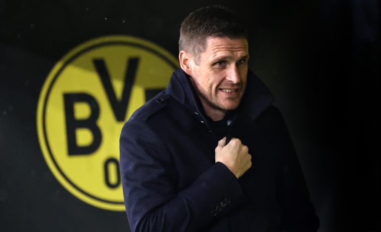 Sebastian Kehl steht vor dem Borussia Dortmund Logo