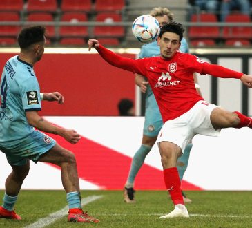 Timur Gayret nimmt einen Ball vor einem Verteidiger Volley.