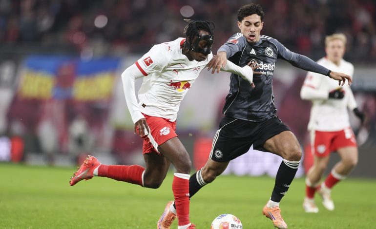 Yan Diomande von RB Leipzig läuft mit dem Ball, während er unter Druck von Farès Chaïbi von Eintracht Frankfurt steht.