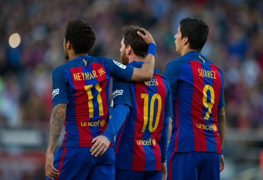 Neymar, Lionel Messi und Luis Suarez stehen im Barca Trikot nebeneinander.