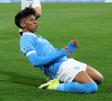 Alisson Santos rutscht auf den Knien im Heimtrikot der SSC Neapel, um sein Tor gegen die Roma zu feiern.