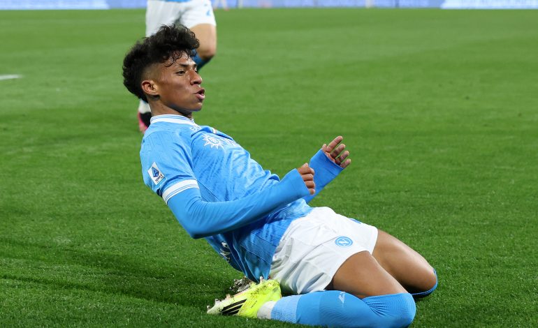 Alisson Santos rutscht auf den Knien im Heimtrikot der SSC Neapel, um sein Tor gegen die Roma zu feiern.